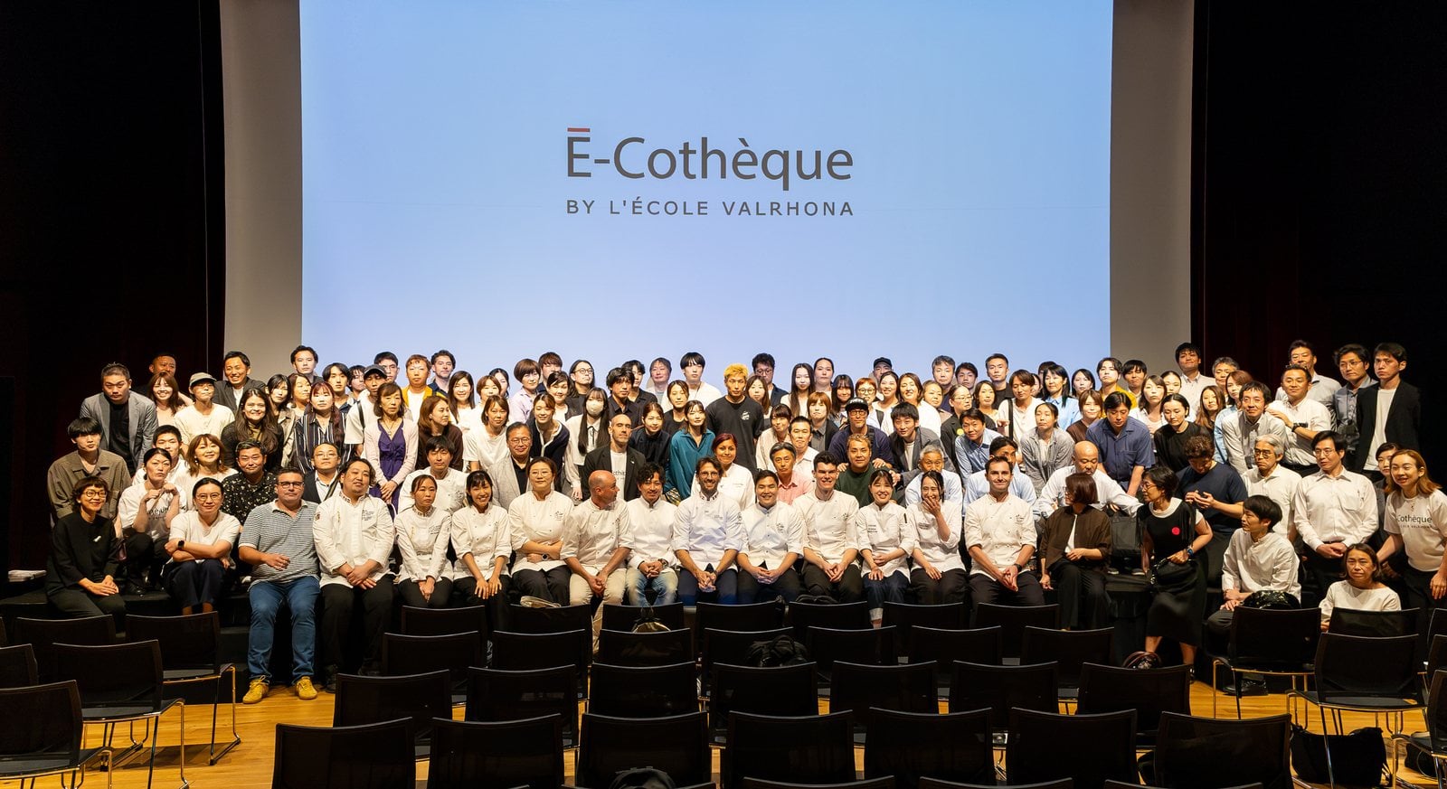 Foto de grupo de todos los asistentes a É-Cothèque 2026 sobre el escenario, bajo el logotipo del evento
